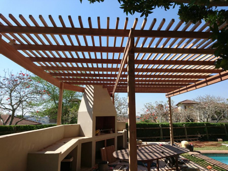 swimming pool area with bbq and wooden pergola near gibraltar