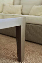 Aluminium outdoor table leg with a fibre sofa in the background.