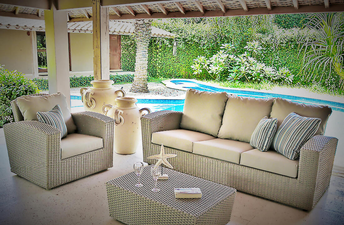 Garden set of sofa nad armchair made of wicked rope with a background of antique clay anphoras with swimiming pool, tropical garden in a villa in Marbella