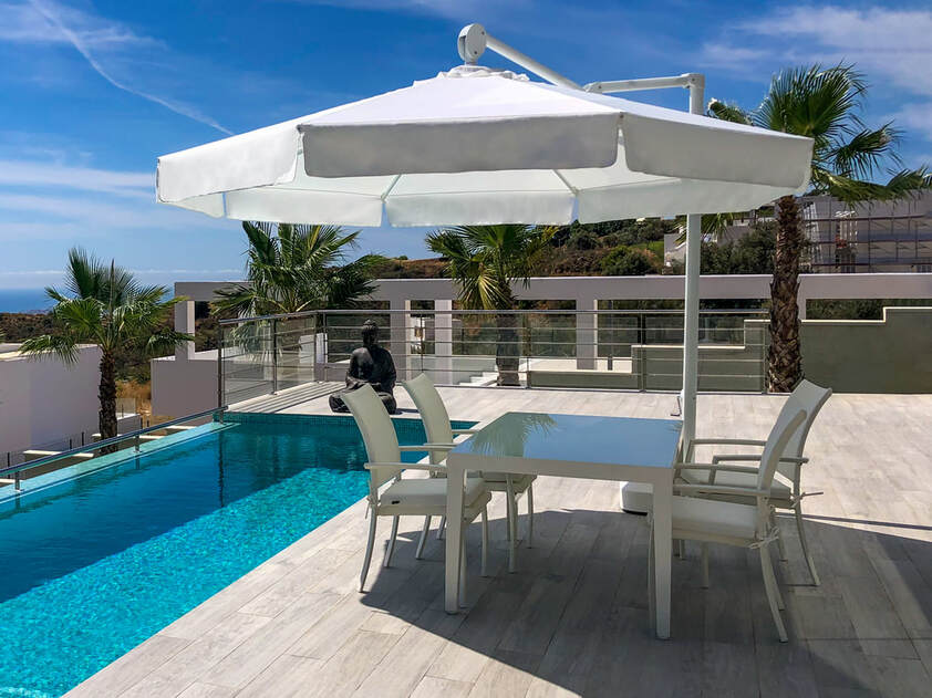 Swimming pool umbrella in a penthoues in Estepona Spain during the las summertime dining hours