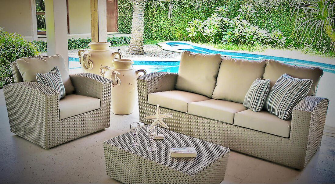 Rope weaved sofa set in a pool porche with big sofa and armchair with stripe decorative cushions and two antique clay anphora in a villa in Estepona