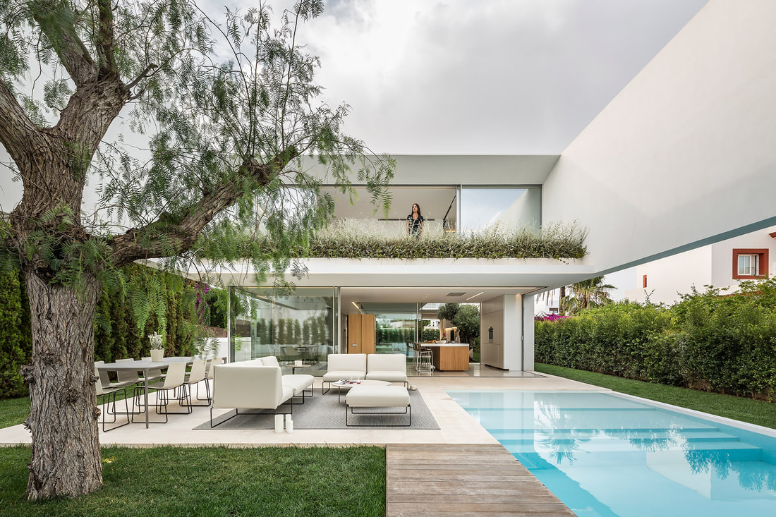 Industrial house in white colours and modern high end outdoor furniture.